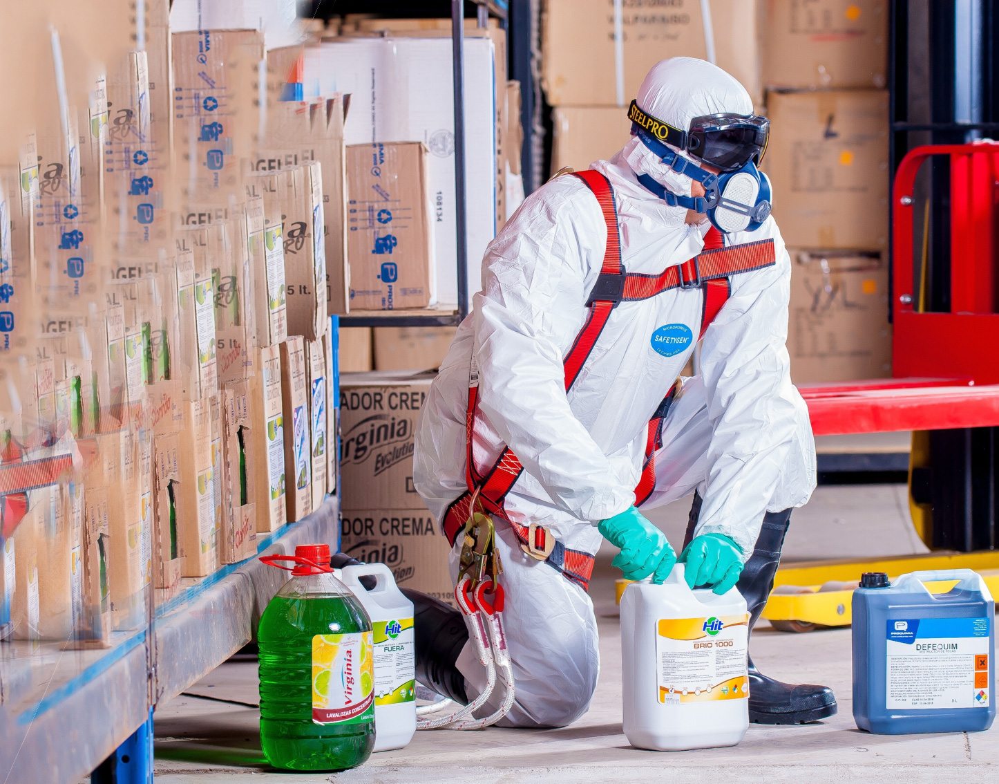 Clean management worker wearing full protective suit opening a white jug of unknown substance